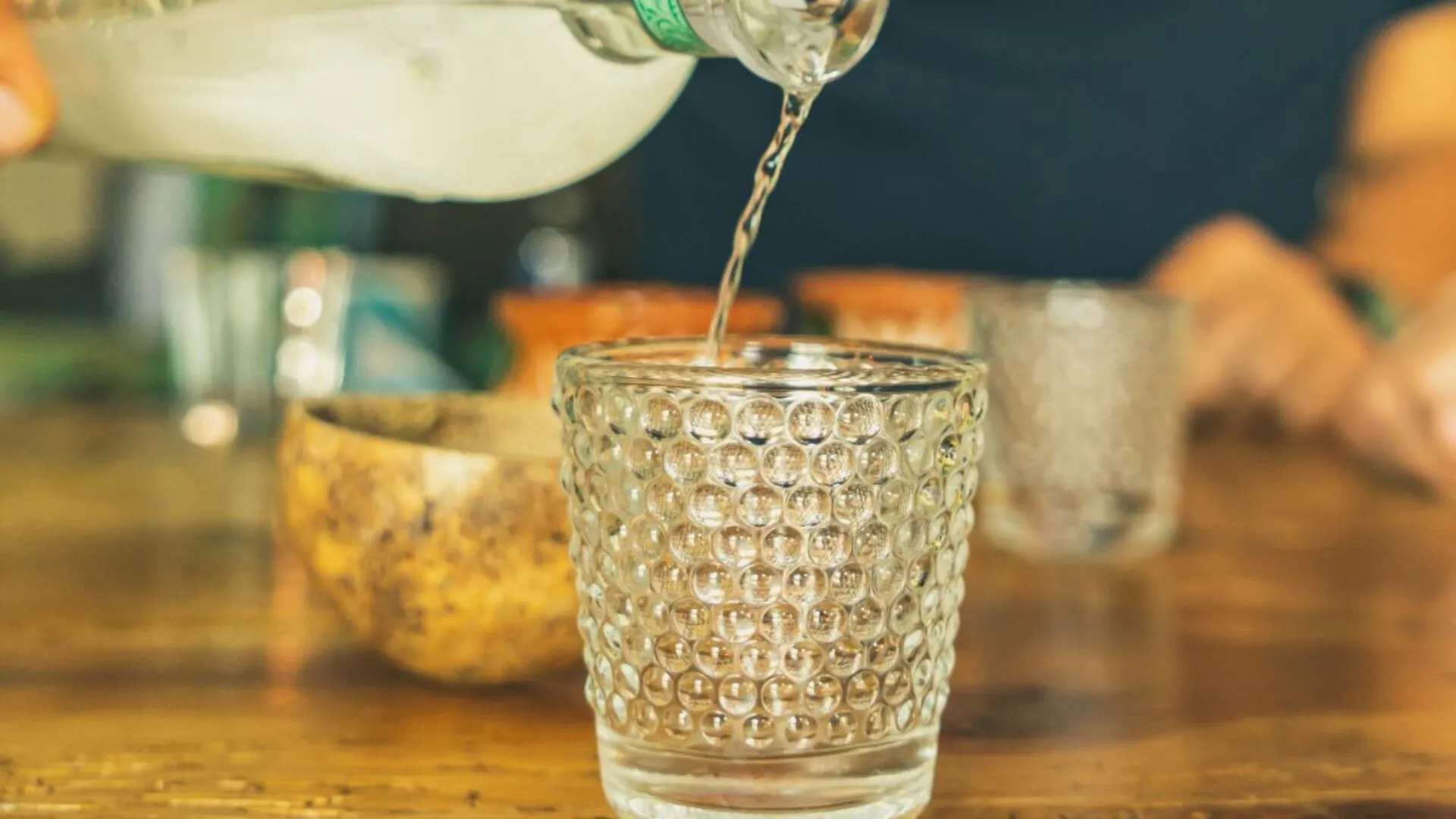 Mezcal being poured from a bottle into a glass